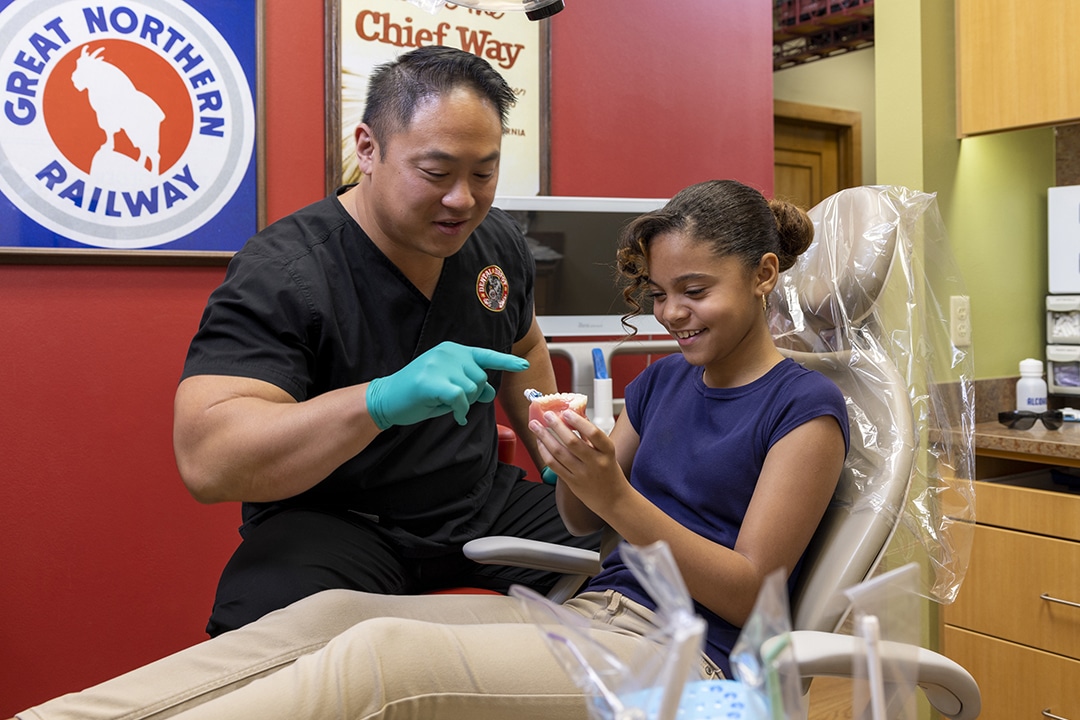 A young girl learns to properly brush at dental depot