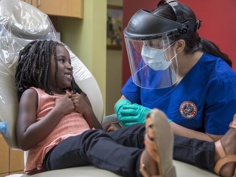 A small child talks with a dental hygienist at dental depot