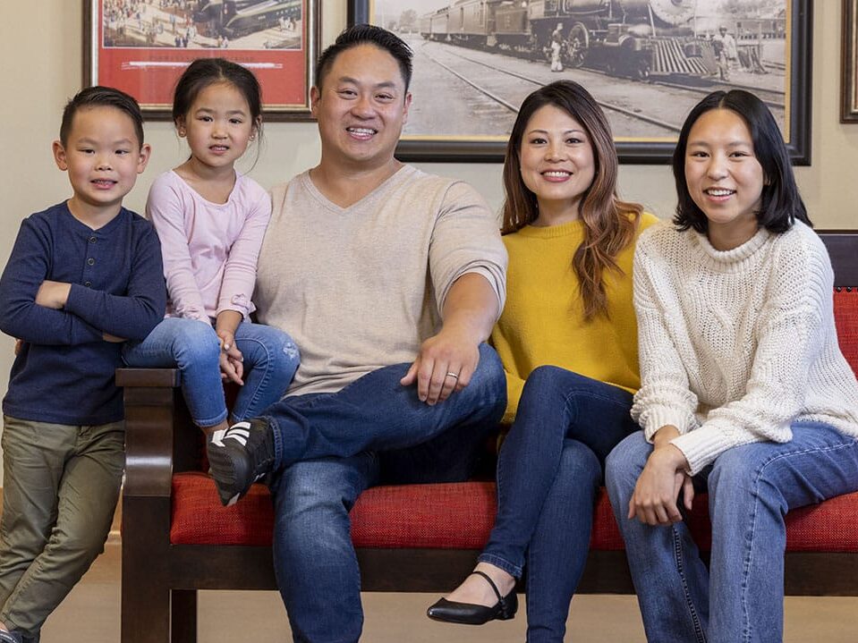 A family smiles as they wait patiently in dental depots lobby