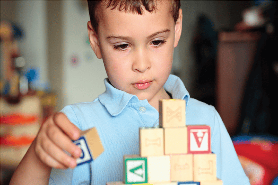 Child with autism playing with building blocks